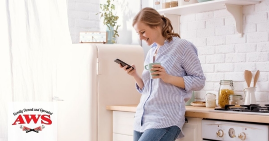 Woman in bright kitchen on her phone
