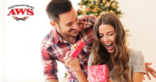 woman opening gift with man behind her