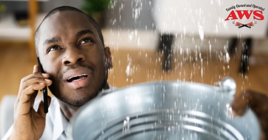 man holding bucket up under a leak