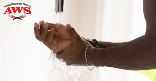 mans hands running under water from faucet