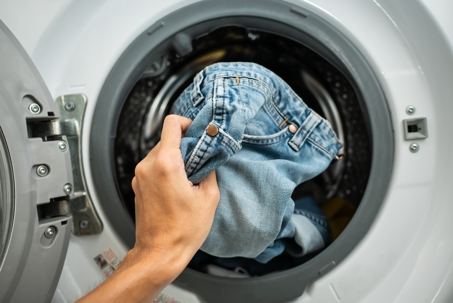 Woman pulling jeans out of the washer