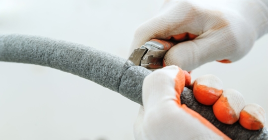 Cutting insulation on pipe.