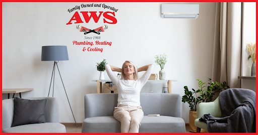 Woman relaxing on a couch with her ductless HVAC unit behind her.